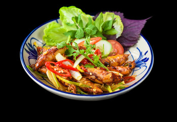 Fried squid with vegetables on black background for a menu