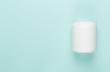 Plastic bottle with vitamins on color background, top view