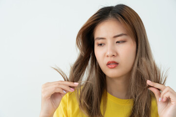 Asian woman very sad and upset looking at damaged hair, hair loss, hair thinning problem, vitamin...