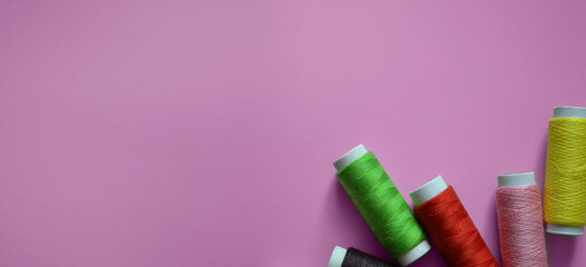 spools of thread on a pink background, a banner for an atelier, tailoring, a photo for a sewing workshop, sewing threads, a place for text
