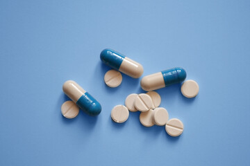 capsules and tablets on a blue background, photos for a medical website, medicines, a banner for a medical clinic, medical care, a place for text