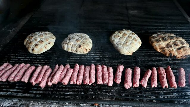 Cevapcici or cevapi on the grill. Balkans traditional food. Grilled dish of minced meat and bread. Barbecue.  