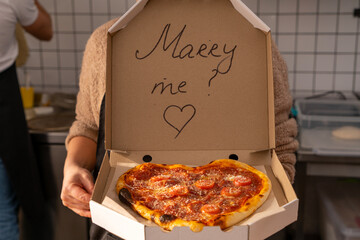 A romantic proposal of love with delicious pizza and the inscription on the box of Merry Me
