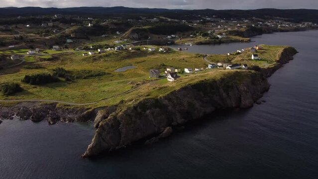 Aerial evening Newfoundland homes overlooking high rocky cliffs and Gun Hill Lookout near Devils Cove on Canada's East Coast.
