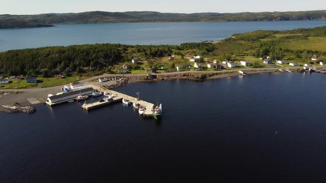 Aerial fishing pier with trawlers and small East coast community on a narrow peninsula at Summerville Newfoundland Canada.
