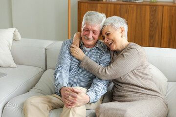 Senior adult mature couple hugging at home. Mid age old husband and wife embracing with tenderness...