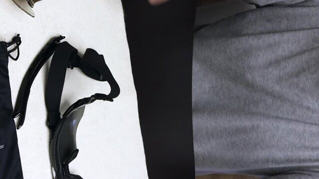 A man installs a fixing elastic band instead of the temples of sunglasses. Glasses with interchangeable colored lenses. A blogger makes a review of sunglasses. vertical video.