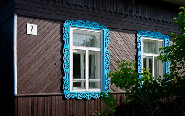 Deux fenêtres encadrées avec des chambranles bleus en bois sculpté ornés de motifs...