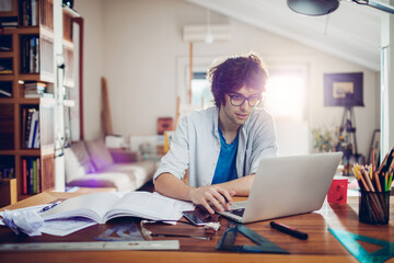 Young caucasian man using a laptop at studying at home