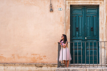 Fototapeta na wymiar Girl in dress on balcony Italy