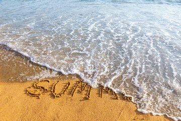 Summer inscription washing away by wave