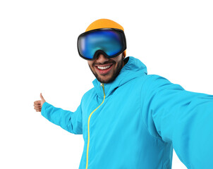Smiling young man in ski goggles taking selfie and showing thumbs up on white background