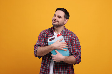 Man holding canister with blue liquid on orange background