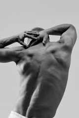 Male body aesthetics. Black and white image of strong, muscular, beautiful, relief male back. Healthy body shape. Concept of male natural beauty, body care, health, sport, fashion, ad