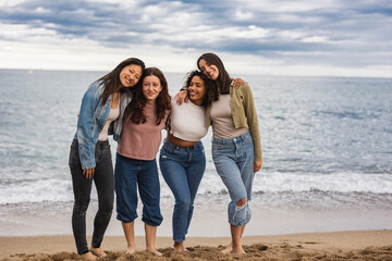 group of multiracial diverse female friends together on the beach