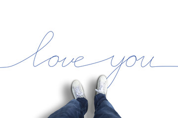 A man in white shoes stands on a white floor with blue illustrated inscription love you. 
