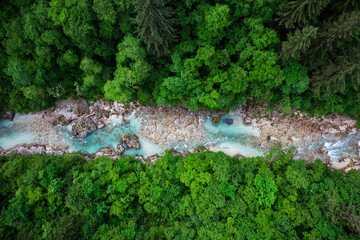 Soca river in Slovenia. Aerial drone top down view of emerald green river in forest
