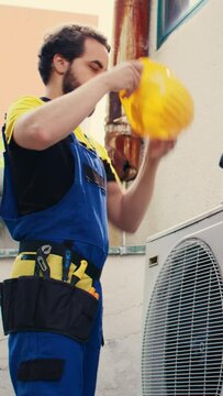 Vertical video Knowleadgeable engineer arriving on location to help fix system electrical issues caused by improper wiring or broken capacitor requiring professional intervention to diagnose and