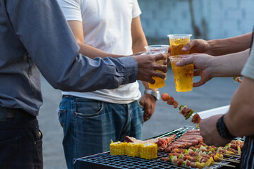 Beer drinks prepared for barbecue party among friends are served in plastic glasses because plastic...