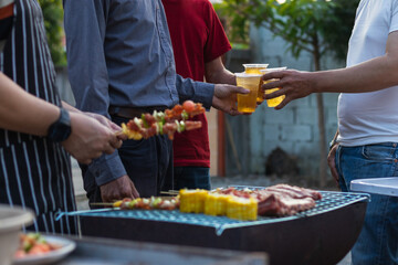 Beer drinks prepared for barbecue party among friends are served in plastic glasses because plastic glasses can be easily stored at end of party. Easy party idea by serving beer in plastic glasses.