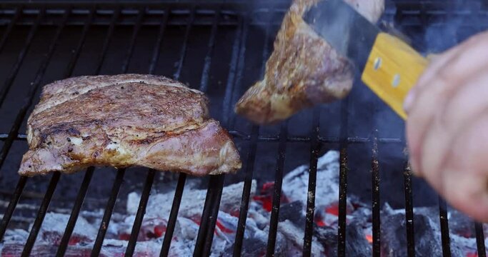 Grilling pork chuck steak on flaming prepared grill gives it beautiful charred appearance.