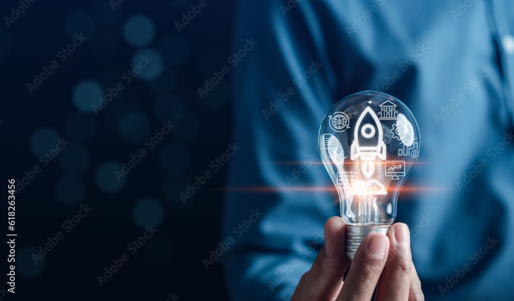 Aufkleber hand business holding light bulb with rocket launch icon, fast start up business to goal and success