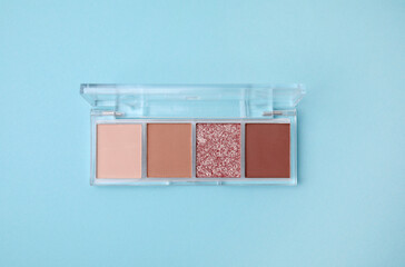 Beautiful eye shadow palette on light blue background, top view
