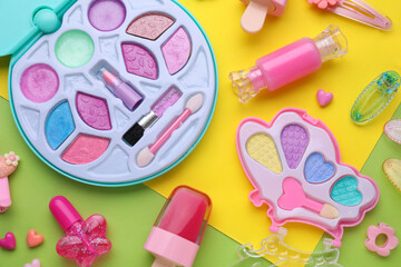 Eye shadow palette and other decorative cosmetics for kids on color background, flat lay