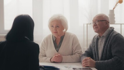 Senior couple talking to health insurance agent, listening contract conditions