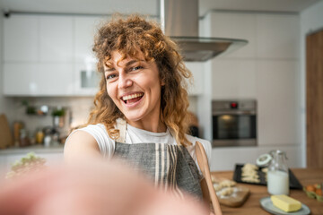 One happy young adult caucasian woman wear apron in the kitchen smile