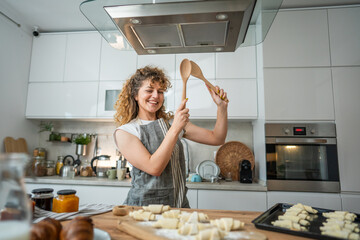 One happy young adult caucasian woman wear apron in the kitchen smile