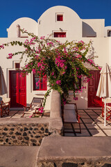 White Tradional House Oia with Red Doors and Windows - Bougainvillea Flowers in Imerovigli Village in Santorini Island, Greece - Caldera Cliffs