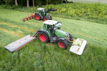 Abmähen einer Wiese und gleich das Gras wenden, Trecker mit Mähbalken und ein Trecker mit...