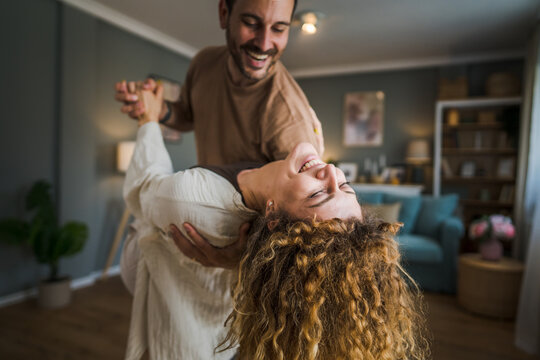 Happy couple adult caucasian man woman husband and wife dance at home