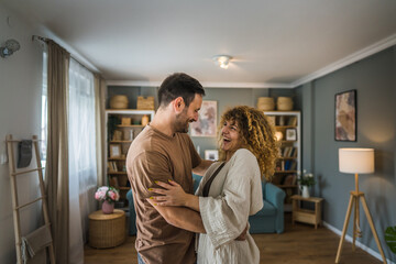 Happy couple adult caucasian man woman husband and wife dance at home