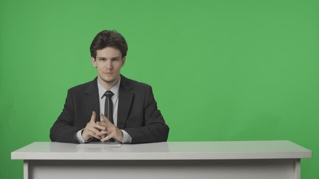 Anchorman on green screen background. The end of the news release, the man finishes the report, the studio plunges into darkness, the man leaves. Advertising area. HDR BT2020 HLG Material.