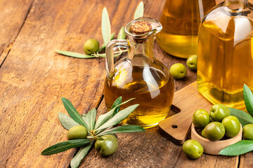 Olive oil and olive branch. extra virgin olive oil jars on a wooden background. place for text