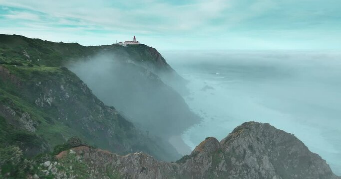 Aerial view pf the most western point of the European continent - Cabo da Roca, Portugal. Drone flies over the Atlantic ocean coast, rocky formations and the beach called Praia da Ursa.