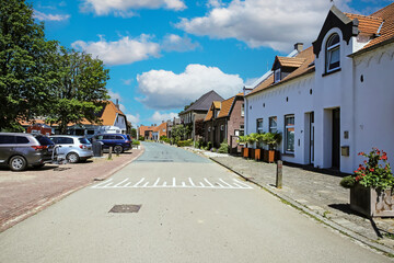 Oud Bergen, Netherlands - June 9. 2023: Empty street in dutch sleepy rural village, blue summer sky