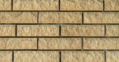 Part of the wall, sand-colored decorative brick. closeup pattern