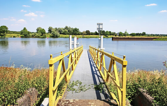 Empty yellow boat landing pier jetty at dutch sluis, Maas river - Sambeek sluice, Netherlands