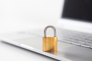 Gold locked padlock on laptop. Computer security concept. Close up