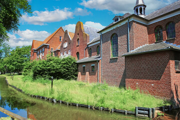 Fototapeta na wymiar Ancient old red brick stone monastery building, water moat - Boxmeer (De Weijer), Netherlands