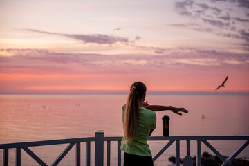 Fototapeta premium Young woman does warm-up in morning before running training. Healthy fitness