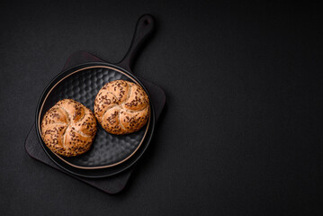 Delicious freshly baked crispy bun or kaiser roll with sesame seeds - obrazy, fototapety, plakaty