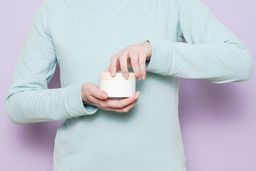 Jar or bottle for cosmetic product in female's hand. Spa