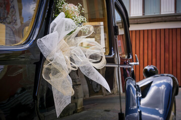 Old-style vehicle decorated with flowers and bows to carry the bride and groom to a wedding