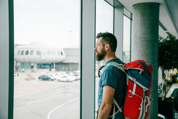 handsome man with backpack waiting in airport