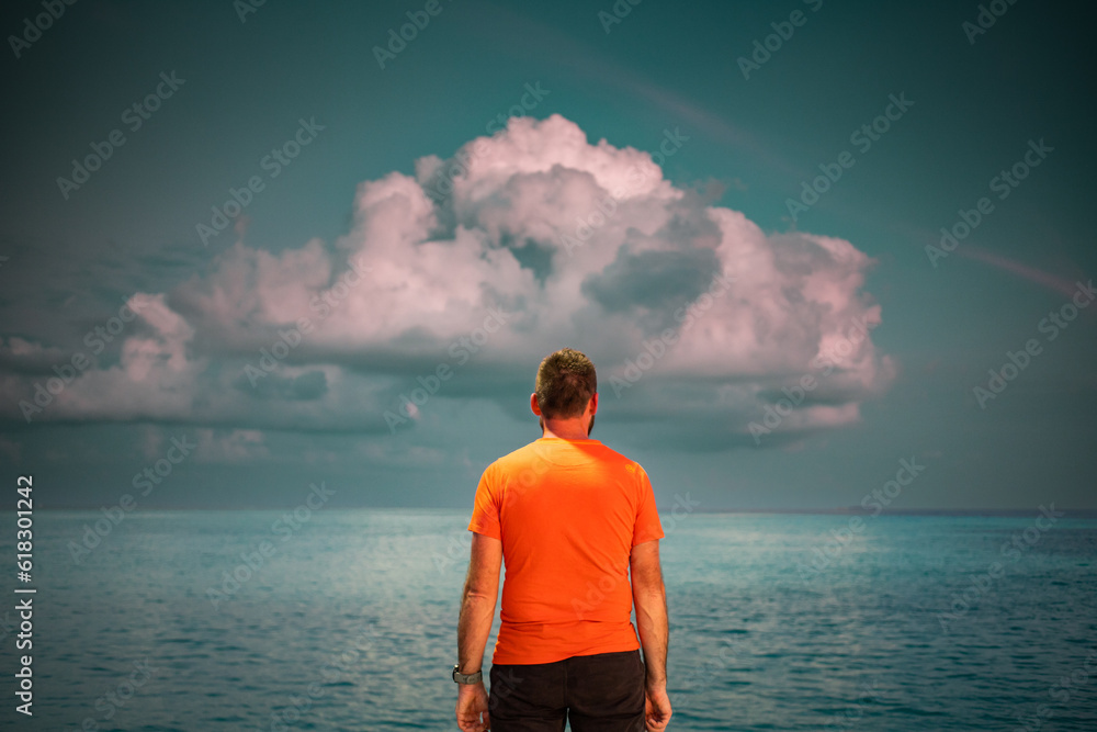 Wall mural man looking at  sunset cloud over tropical sea freedom