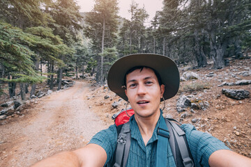 Happy man traveler naturalist against the backdrop of a Lycian way in the woods and mountain landscape background